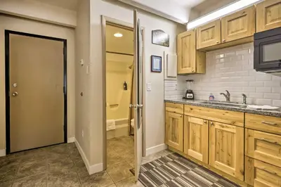 a kitchen with wooden cabinets and a door to a bathroom at Lakefront Condo with Mtn Views in Dillon! in Dillon