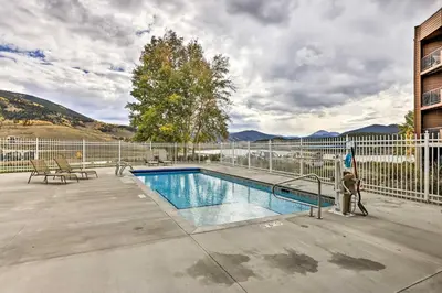 a swimming pool next to a fence and a building at Lakefront Condo with Mtn Views in Dillon! in Dillon