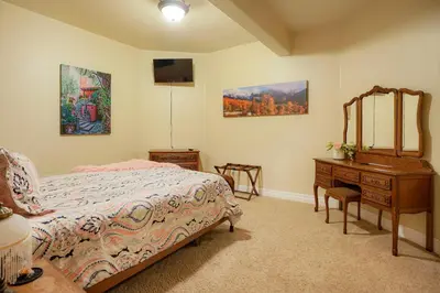 a bedroom with a bed and a dresser and a mirror at Summit Villa BnB in Watkins