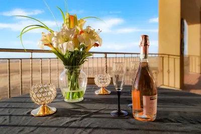 a bottle of wine and glasses on a table with flowers at Summit Villa BnB in Watkins