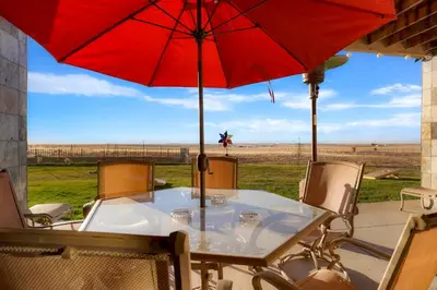 a table with a red umbrella and chairs at Summit Villa BnB in Watkins