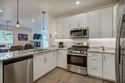 a kitchen with white cabinets and stainless steel appliances at Brand New Clear Water Lofts - 2br Premier Condo - Kids Ski Free! condo in Keystone