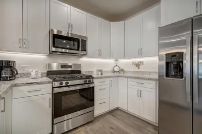 a kitchen with white cabinets and stainless steel appliances at Brand New Clear Water Lofts - 2br Premier Condo - Kids Ski Free! condo in Keystone