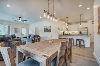 a kitchen and living room with a wooden table and chairs at Brand New Clear Water Lofts - 2br Premier Condo - Kids Ski Free! condo in Keystone