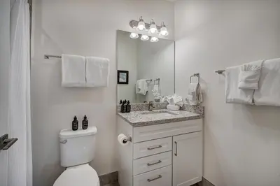 a bathroom with a toilet and a sink and a mirror at Brand New Clear Water Lofts - 2br Premier Condo - Kids Ski Free! condo in Keystone