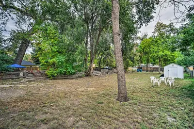 a yard with two white chairs and a tree at Charming Fort Collins Home By Old Town and CSU! in Fort Collins