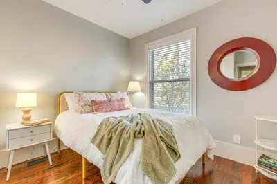 a bedroom with a bed and a mirror on the wall at Furnished Patio and Yard Denver Bungalow! in Denver