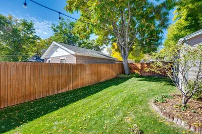 a backyard with a wooden fence and a yard at Furnished Patio and Yard Denver Bungalow! in Denver