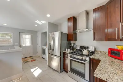 a kitchen with stainless steel appliances and wooden cabinets at Furnished Patio and Yard Denver Bungalow! in Denver