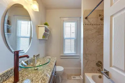 a bathroom with a sink and a toilet and a mirror at Furnished Patio and Yard Denver Bungalow! in Denver