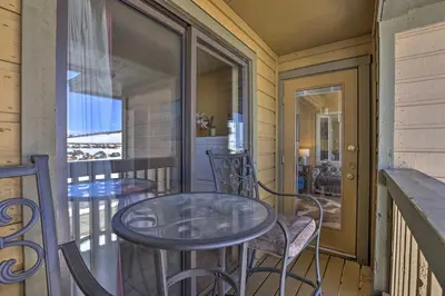 a porch with a table and chairs on a balcony at Cozy Ski-InandSki-Out Granby Condo with Balcony! in Granby