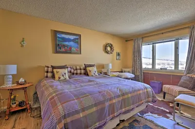 a bedroom with a bed and a couch and a window at Cozy Ski-InandSki-Out Granby Condo with Balcony! in Granby