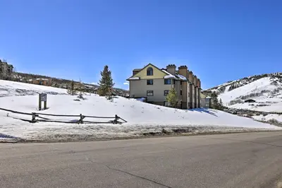 a house on top of a snow covered hill with a street at Cozy Ski-InandSki-Out Granby Condo with Balcony! in Granby