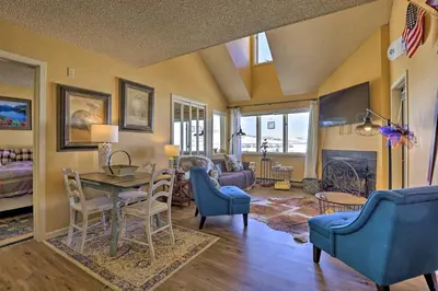 a living room with blue chairs and a table at Cozy Ski-InandSki-Out Granby Condo with Balcony! in Granby