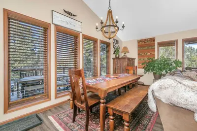 a dining room with a table and some windows at Panoramic View Home with Hot Tub & Game Room in Black Hawk