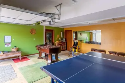 a ping pong table in a room with green walls at Panoramic View Home with Hot Tub & Game Room in Black Hawk