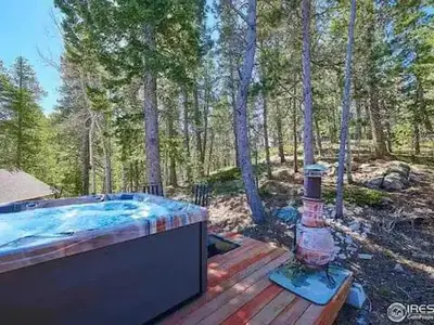 a hot tub sitting on top of a wooden deck at Panoramic View Home with Hot Tub & Game Room in Black Hawk