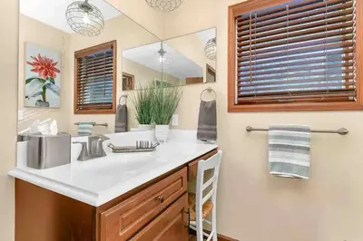 a bathroom with a sink and a mirror at Panoramic View Home with Hot Tub & Game Room in Black Hawk