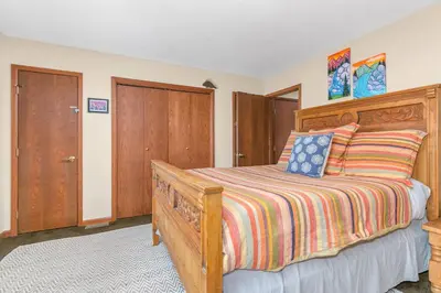 a bedroom with a wooden bed with a wooden headboard at Panoramic View Home with Hot Tub & Game Room in Black Hawk