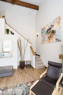 a living room with a chair and a staircase at Sundance-2 miles to Rocky Mountain National Park in Estes Park
