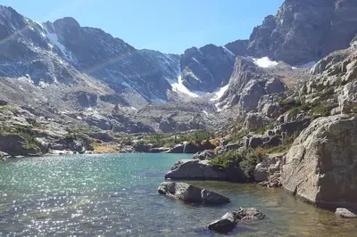 a mountain lake with a rainbow in the background at Sundance-2 miles to Rocky Mountain National Park in Estes Park