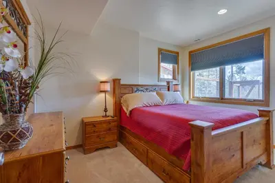 a bedroom with a wooden bed and a window at Beautiful 7 BEDROOM, 3 gathering areas, pool table, hot tub, and huge deck with 360-degree views!! in Silverthorne