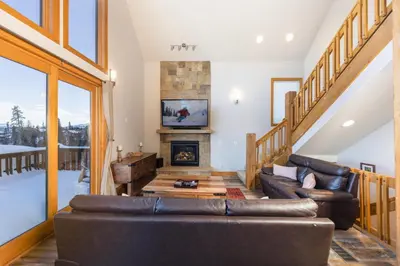 a living room with a couch and a fireplace at Beautiful 7 BEDROOM, 3 gathering areas, pool table, hot tub, and huge deck with 360-degree views!! in Silverthorne