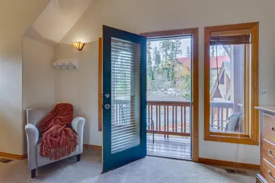 a room with a door and a chair and a balcony at Beautiful 7 BEDROOM, 3 gathering areas, pool table, hot tub, and huge deck with 360-degree views!! in Silverthorne