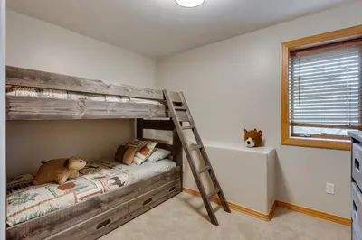 a bedroom with a wooden bunk bed with a teddy bear at Beautiful 7 BEDROOM, 3 gathering areas, pool table, hot tub, and huge deck with 360-degree views!! in Silverthorne