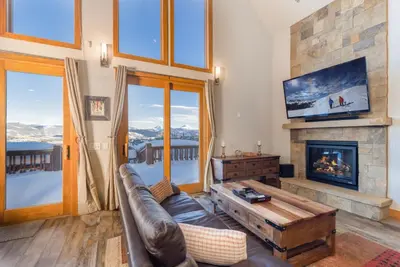 a living room with a couch and a fireplace at Beautiful 7 BEDROOM, 3 gathering areas, pool table, hot tub, and huge deck with 360-degree views!! in Silverthorne
