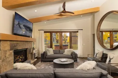 a living room with a couch and a fireplace at LUXURY HOME by the river! Walk to Shuttle, Hot Tub, Fire Pit, designer finishes!! in Breckenridge