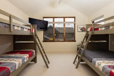 two bunk beds in a room with a window at LUXURY HOME by the river! Walk to Shuttle, Hot Tub, Fire Pit, designer finishes!! in Breckenridge