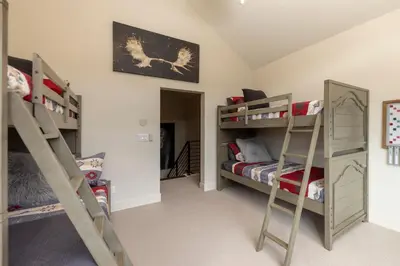 a room with three bunk beds and a bed at LUXURY HOME by the river! Walk to Shuttle, Hot Tub, Fire Pit, designer finishes!! in Breckenridge