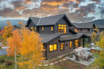 a home with a black house with a table and chairs at LUXURY HOME by the river! Walk to Shuttle, Hot Tub, Fire Pit, designer finishes!! in Breckenridge