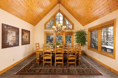 a dining room with a wooden table and chairs at Warm, Spacious, and Elegant Breckenridge Home near golf course, hot tub, arcade machine, foosball in Breckenridge