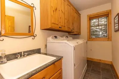 a bathroom with a sink and a washing machine at Warm, Spacious, and Elegant Breckenridge Home near golf course, hot tub, arcade machine, foosball in Breckenridge
