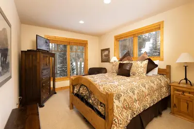 a bedroom with a bed and a dresser and windows at Warm, Spacious, and Elegant Breckenridge Home near golf course, hot tub, arcade machine, foosball in Breckenridge