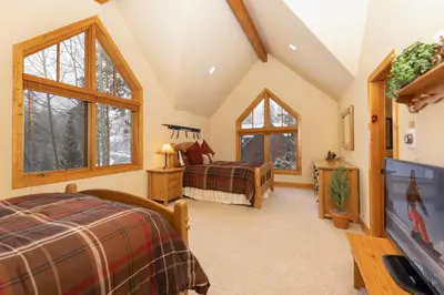 a bedroom with two beds and two windows at Warm, Spacious, and Elegant Breckenridge Home near golf course, hot tub, arcade machine, foosball in Breckenridge