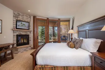 a bedroom with a bed and a fireplace at Four master suites, VIEWS!! Hot tub, private ski SHUTTLE, sprawling entertaining areas!! in Breckenridge