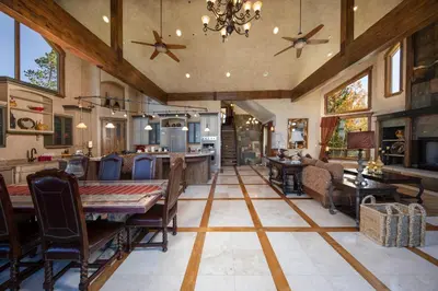a kitchen and living room with a table and chairs at Four master suites, VIEWS!! Hot tub, private ski SHUTTLE, sprawling entertaining areas!! in Breckenridge