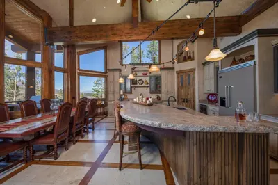 a kitchen with a large counter and a dining room at Four master suites, VIEWS!! Hot tub, private ski SHUTTLE, sprawling entertaining areas!! in Breckenridge
