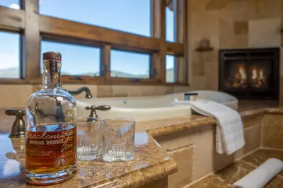 a bottle of whiskey sitting on a counter in a bathroom at Four master suites, VIEWS!! Hot tub, private ski SHUTTLE, sprawling entertaining areas!! in Breckenridge