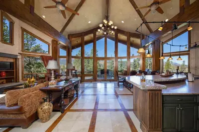 an open kitchen and living room with large windows at Four master suites, VIEWS!! Hot tub, private ski SHUTTLE, sprawling entertaining areas!! in Breckenridge