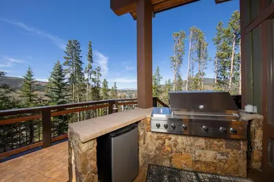 a grill on a deck with a view at Four master suites, VIEWS!! Hot tub, private ski SHUTTLE, sprawling entertaining areas!! in Breckenridge