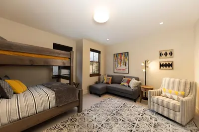 a bedroom with a bed and a couch at Modern Elegance, Stunning Mountain Views, Hot Tub, Fire Pit, Walk to River! in Breckenridge