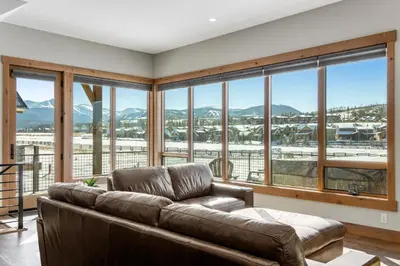 a living room with a couch and large windows at Fraser Wonder in Fraser