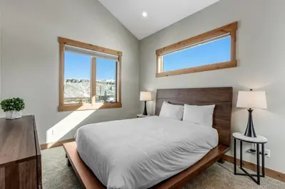a bedroom with a large bed and two windows at Fraser Wonder in Fraser