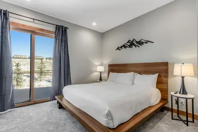 a bedroom with a bed and a large window at Fraser Wonder in Fraser