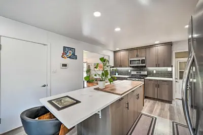 a kitchen with wooden cabinets and a refrigerator at Less Than 7 Mi to Dtwn Denver Home with Large Yard! in Denver