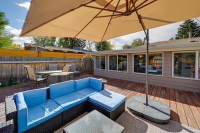 a patio with a blue couch and an umbrella at Less Than 7 Mi to Dtwn Denver Home with Large Yard! in Denver